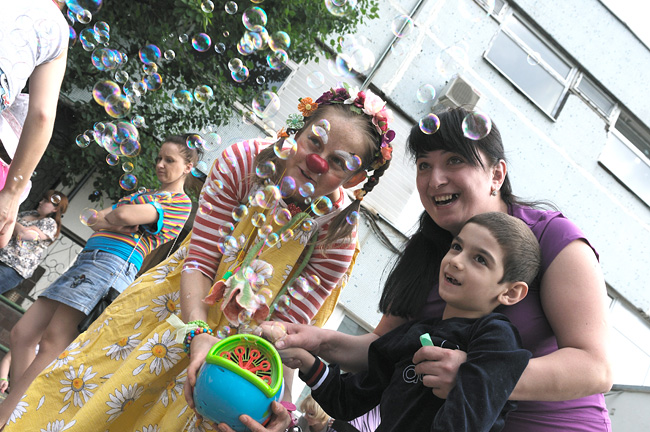 Клоуны помогают детям запускать мыльные пузыри