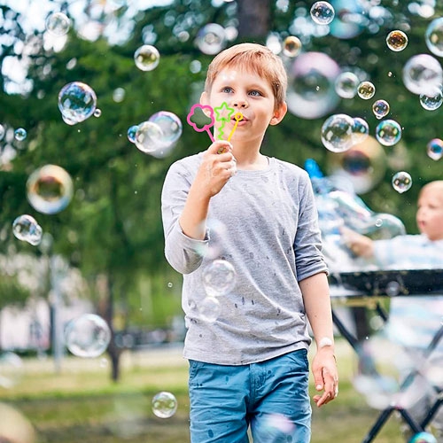 Мальчик выдувает мыльные пузыри